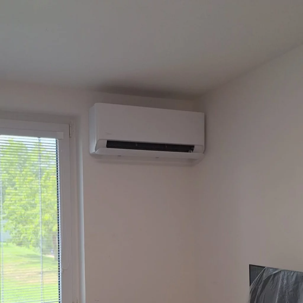 Vnitřní jednotka Videa Breezeless E v bílé barvě vedle okna